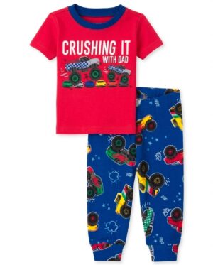 Pijama infantil para niño con camiseta roja Monster Truck y pantalón largo azul estampado con camiones monstruo.